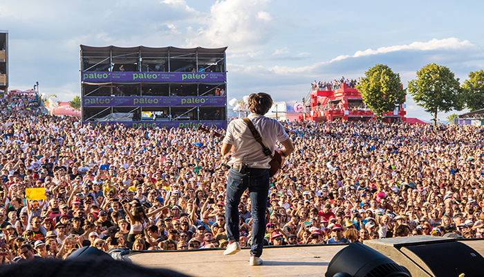 Personne avec guitare devant public